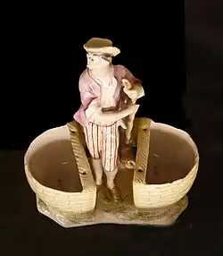 Statuette à deux paniers pour poivre et sel, faïence de Niderviller, XVIIIe&nbsp;siècle.Musée du pain d'épices et de l'art populaire alsacien.