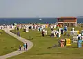 Vue typique de la plage avec sa pelouse : on aperçoit en arrière-plan le port de Wilhelmshaven.