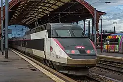 Rame TGV en livrée Carmillon, stationnée à quai sous la halle métallique de la gare.