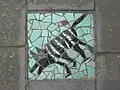 Mosaïque sur le trottoir au no 75