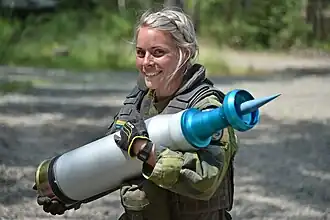 Une tankiste suédoise du régiment de blindés de Skaraborg transportant une munition flèche d'exercice Slövnprj01 lors de la compétition Strong Europe Tank Challenge, en 2018.