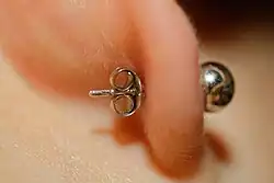 Détail d'une puce d'oreille munie de son fermoir papillon