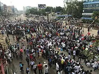 Une foule de manifestants, vue de haut, bloquent une rue.