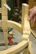 d) Support d'accotoir greffé d'un assemblage à la ceinture.