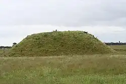 Un tertre de forme allongée recouvert d'herbe.