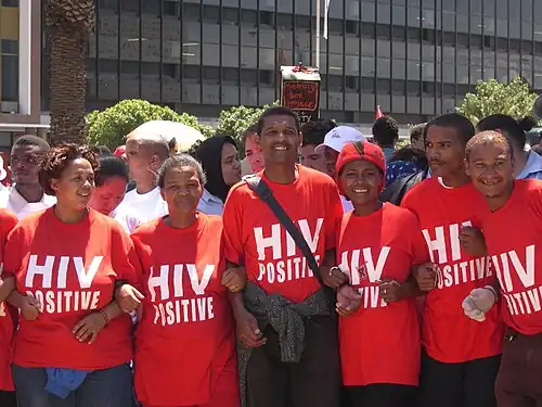Manifestants hommes et femmes aux tee-shirts rouges avec l'inscription «séropositif»