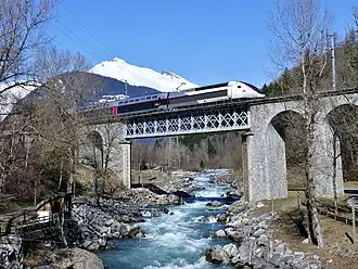 TGV Duplex traversant l'Isère à la sortie de la gare de Bourg-Saint-Maurice