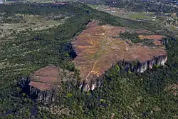 Vue aérienne d'une partie de relief tabulaire parcourue par une piste d'atterrissage.