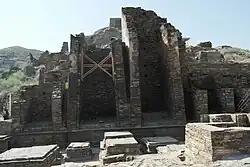 Takht-i-Bahi. Mur de grandes chapelles (14, du Ve&nbsp;siècle) qui contenaient des statues monumentales. La plus haute : 11,30&nbsp;m. Noter le fruit important
