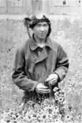Portrait photo noir et blanc d'un hommes en tenue d'aviateur dans un champ.