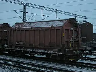 Wagon-trémie couvert Tau à parois latérales basculantes pour le transport du talc (Finlande).