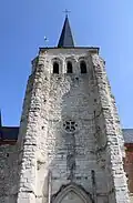 Le clocher fortifié en pierre calcaire date du XIe siècle. En haut, trois baies de style roman éclairent la salle de refuge. De chaque côté, une tour percée de trois meurtrières et soutenue par un cul-de-lampe sculpté est intégrée dans chaque contrefort.