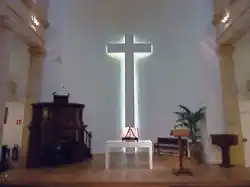 Intérieur du temple, chaire, table, bible, baptistère et croix.