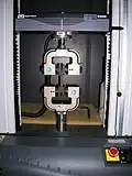 Essai de traction sur une éprouvette composite (fixée verticalement et centrée entre les mors).