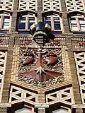 Gros plan du blason sur le portique d'entrée.