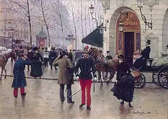 Portait d'un militaire se tenant debout, dans la rue, devant l'entrée d'un théâtre, au milieu de la foule.
