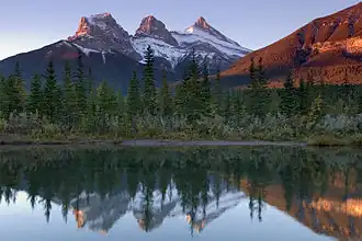 Vue des Three Sisters se reflétant dans la rivière Bow.
