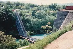 Un pont à demi abattu, dans un paysage boisé.
