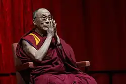 Photographie du dalaï-lama joignant les mains.