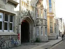 Façade en pierres d'un immeuble percée d'une imposante entrée.