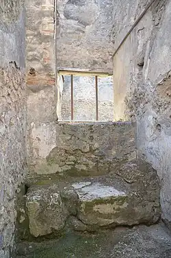 Pièce avec sur le bas une banquette en maçonnerie surplombée d'une fenêtre.