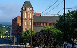 Photo prise depuis une rue d'une tour de briques au bord de la route.