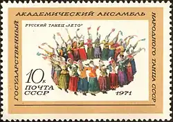 Ronde de femmes en costumes paysans tenant un mouchoir dans une main.