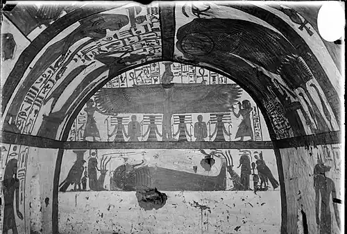 Mur nord (au fond) de la chambre funéraire. Le registre supérieur montre la déesse ailée Nephtys, vénérée par le défunt et sa famille. Le registre inférieur montre la momie du défunt, avec les déesses Nephtys (à gauche) et Isis (à droite) sous forme de faucons de chaque côté de Neferabet. A côté des déesses se trouvent deux figures divines (Khekekh et Djet).
