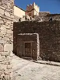 Les maisons du village sont toutes assemblées à partir de décombres. Le linteau d'une maison doté d'un motif à chevrons peut être aperçu. Au cours du XXe&nbsp;siècle, certaines maisons ont été plâtrées.