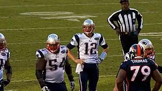 Tom Brady avec la main sur la hanche pendant une rencontre de football américain.