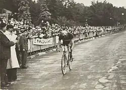 Photographie en noir et blanc d'un cycliste franchissant seul la ligne d'arrivée.