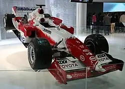 Photo d'une monoplace rouge et blanche, exposée.