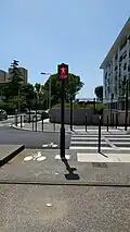 Signal lumineux avec un bonhomme accompagné de la mention « STOP » en rouge clignotant.