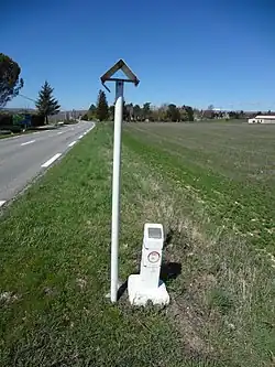 La conduite souterraine d’éthylène est indiquée par un potelet blanc dépassant du sol de 40&nbsp;centimètres environ, et un poteau blanc plus haut coiffé d’un chapeau métallique.