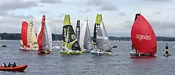 Des voiliers de course se suivent de manière groupée et affalent leur gennaker avant de passer une bouée