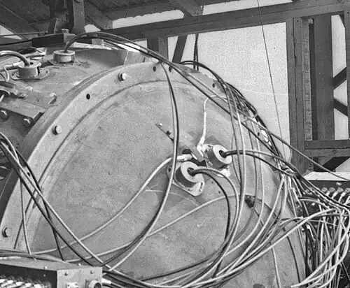 Vue d’un ensemble détonateur de Gadget. L’EBW est le dispositif en Y avec deux câbles parallèles à la surface. Les deux gros objets ronds dont sortent des câbles perpendiculaires à la surface sont des outils de diagnostic.