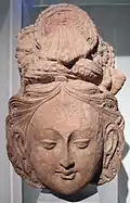 Tête de bodhisattva. Tumshuq, Toqquz-Saraï, grand temple B. Xinjiang. Terre séchée, 43&nbsp;×&nbsp;25&nbsp;cm. VIe&nbsp;siècle - début VIIe&nbsp;siècle. Musée Guimet