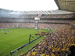 plan large d'un stade rempli de supporters aux couleurs noires et jaunes.