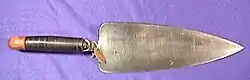 Outil en forme de triangle pointu doté d'un manche permettant de le fixer à l'extrémité d'un fusil.