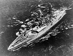 Un grand navire de guerre sur l'eau, vu d'en haut.