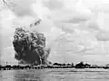 Le USS&nbsp;Mount Hood explose : les traînées de fumée sont laissées par les fragments éjectés par l'explosion.