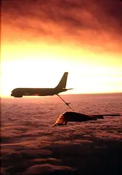 Photographie d'un B-2 acouplé à un KC-135, dans le Soleil couchant.