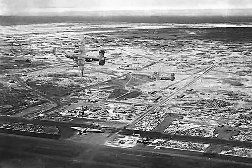 Le XC-105 parqué sur l'île Baltra dans les Galápagos. Les appareils volant au-dessus sont des B-24 Liberator.