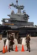 Les soldats du Naval Support Activity Souda Bay's Security Department assurent la surveillance devant le porte-avions français Charles De Gaulle (R 91).