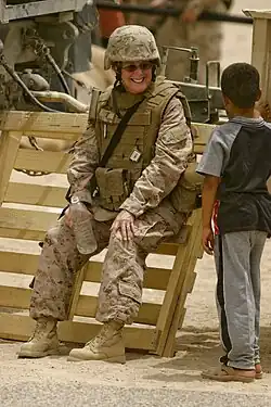Photographie couleur d'une militaire et d'un enfant.