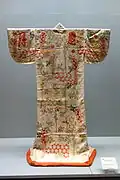 Uchikake aux motifs hexagonaux, fleurs de glycine et caractères japonais sur un satin blanc à motifs, XVIIIe&nbsp;siècle, musée national de Tokyo.