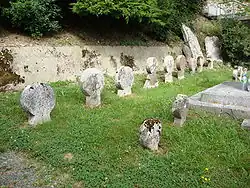 Photographie de deux rangées de stèles discoïdales.