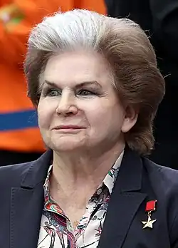 Vieille dame au regard grave en costume, avec une mèche grise