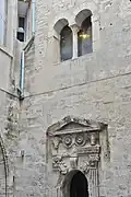 Porte décorée et baie géminée.