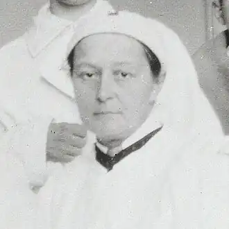 Femme habillée en infirmière regardant la caméra